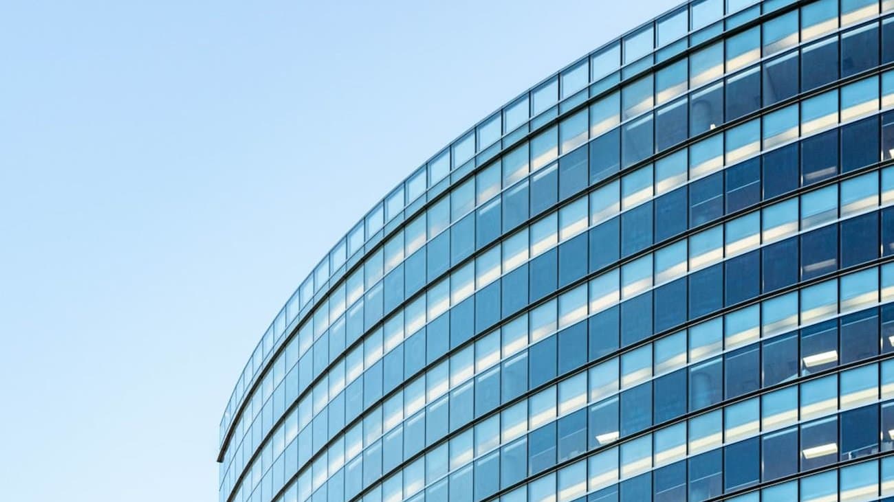 Glass curtain wall of a modern commercial office building against a clear sky