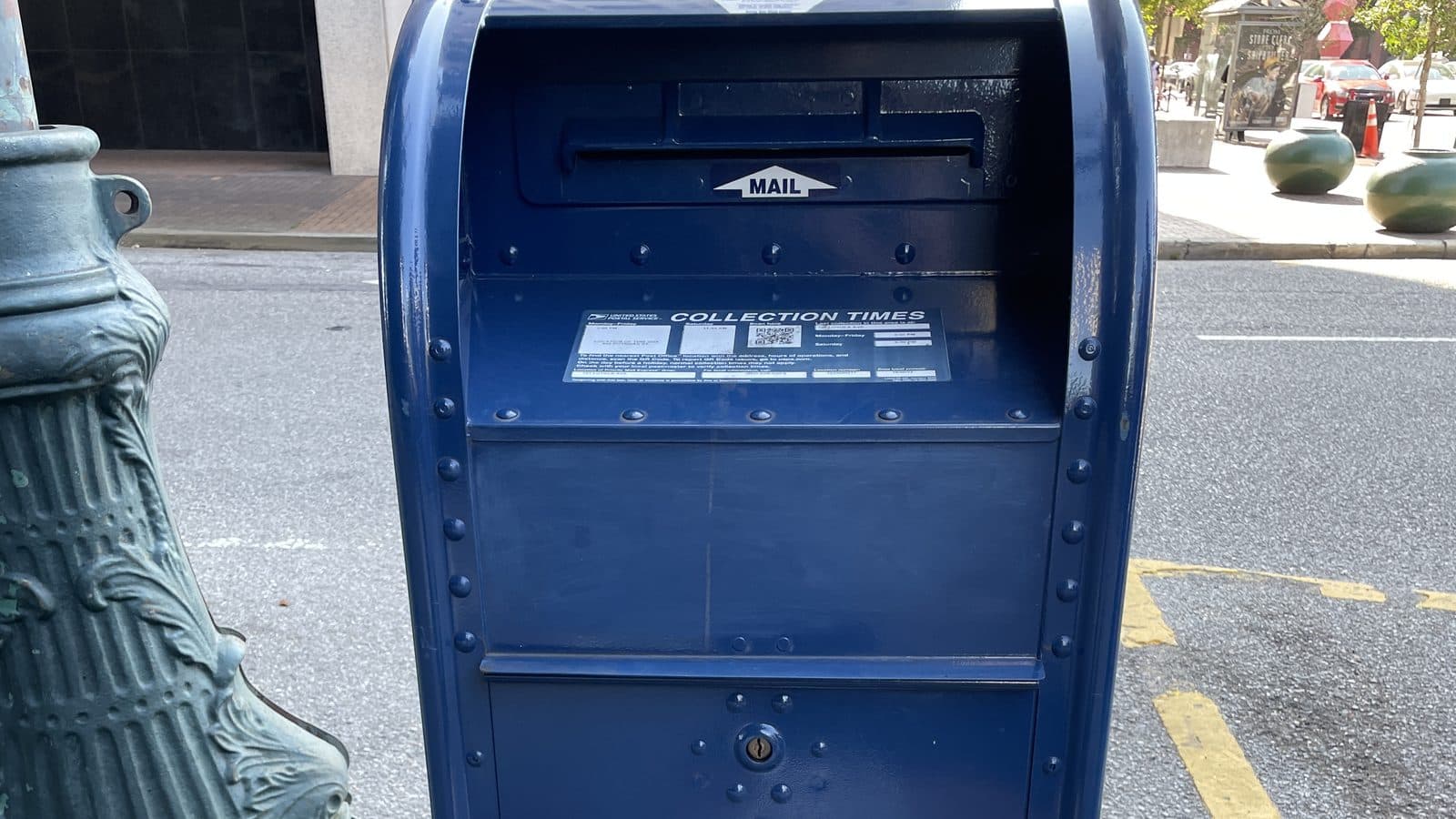 Blue USPS mail collection box on a city street corner